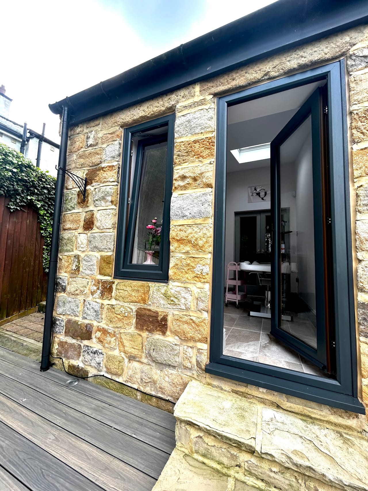 The stone entrance to Beauty By Abigail, with the treatment room visible through the open door